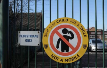 Primary school erects signs banning parents from being on their phones at pickup