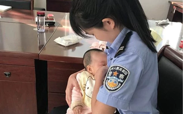 Policewoman breastfeeds crying baby while mother stands in court