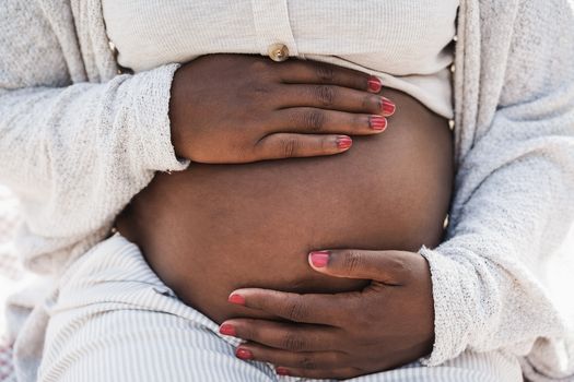 Close up of woman holding her pregnant belly