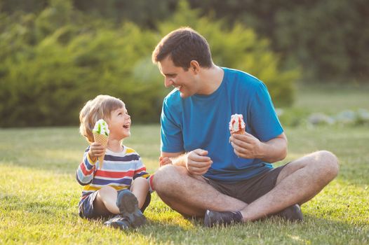 Father and son eating ice cream in the park